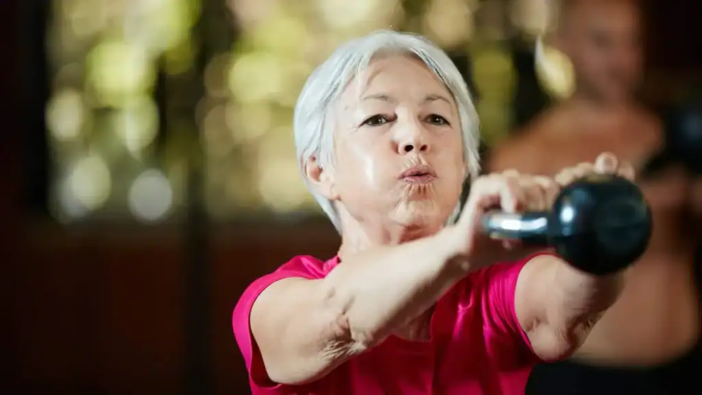 Older woman doing weight training Edgware to help her strength and longevity 